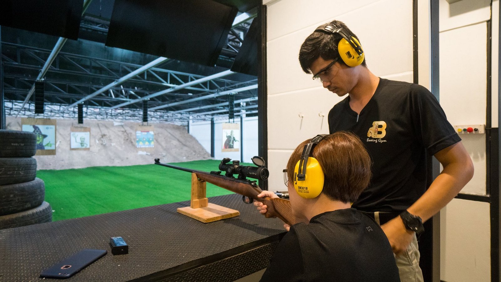 A Light Bullet instructor guiding a first-time shooter on a rifle