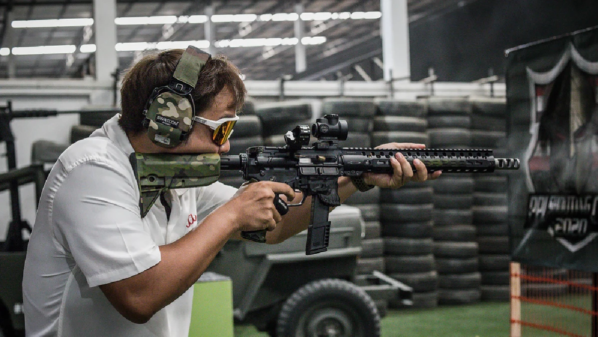 A shooter aiming a rifle at the Light Bullet indoor range