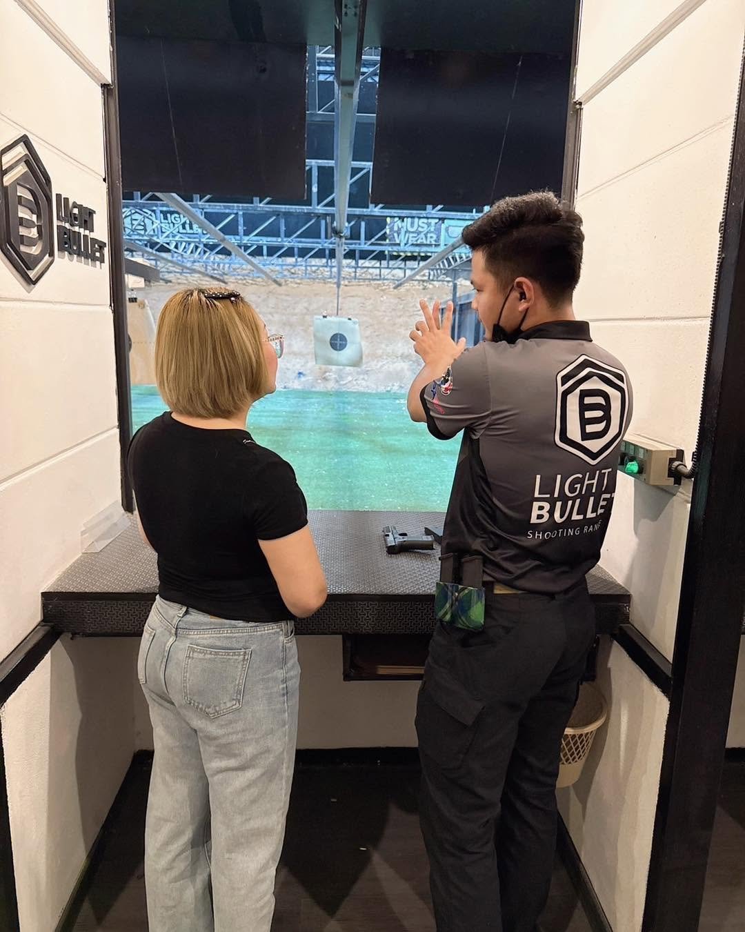 A Light Bullet instructor coaching a shooter at the firing line